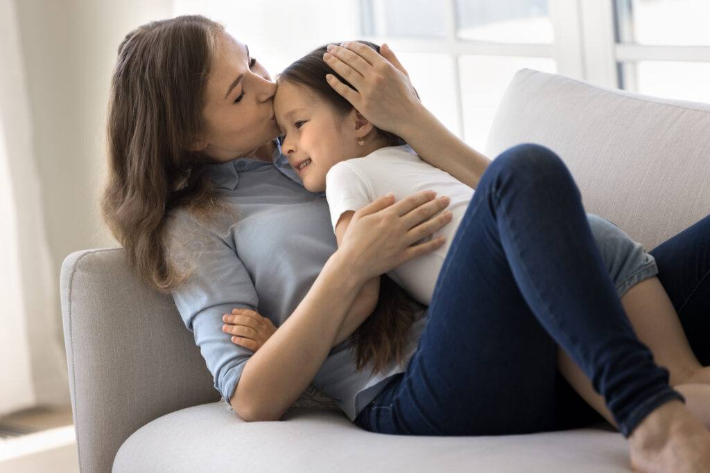 Mother teaching kindness to their child at home through caring communication and positive parenting.